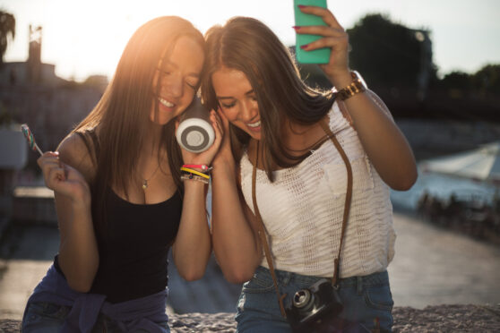 Dívky poslouchají bezdrátový reproduktor