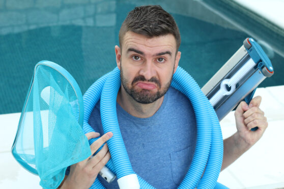 Muž s pomůckami k čištění bazénu