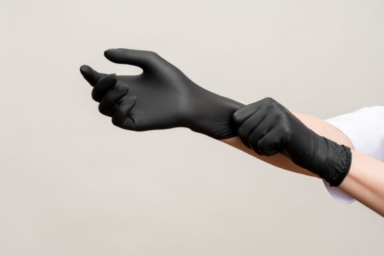Ruce v černých rukavicích