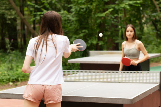 Dívky hrají venku ping pong