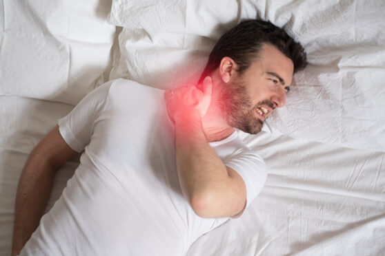 Muž s bolesí krční páteře v posteli