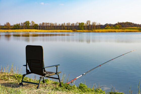 Rybářská židle s prutem u jezera