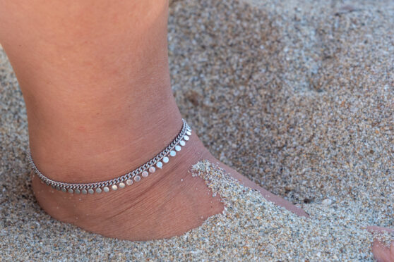 Noha s náramkem v písku