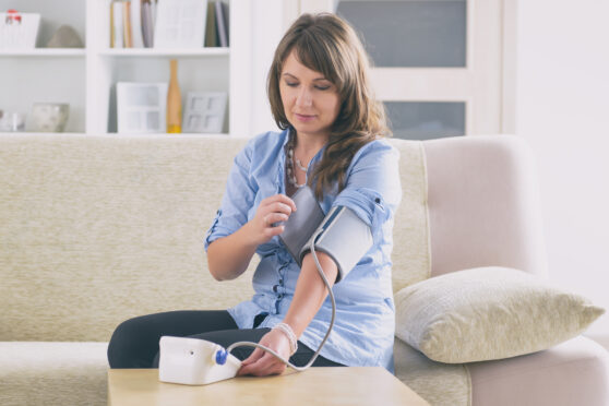 Žena si měří krevní tlak