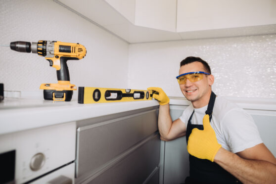 Údržbář instalující kuchyňský nábytek